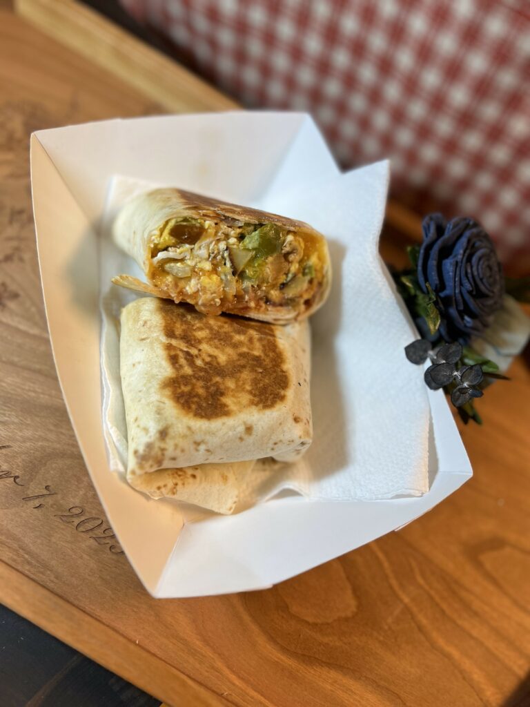 Grilled burrito on wooden table with decorative flower