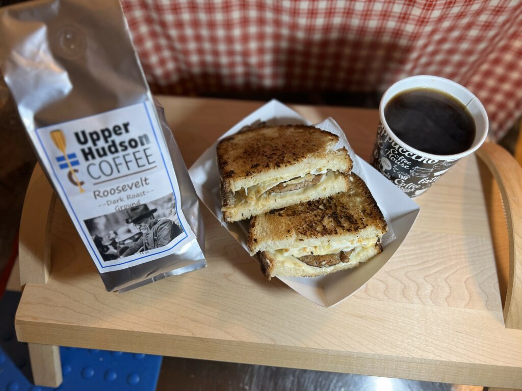 Coffee with grilled sandwich and dark roast coffee bag.