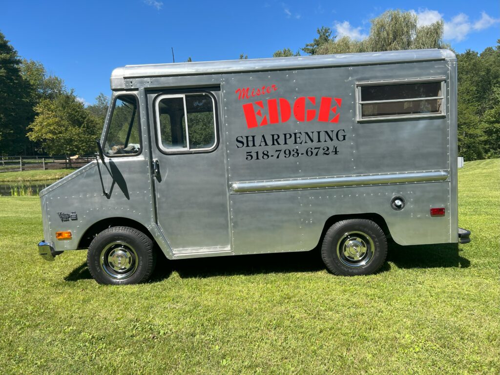 Mobile sharpening service truck on grass.