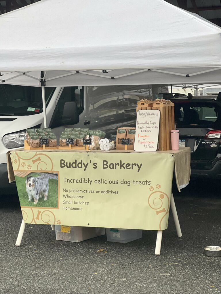 Stall selling homemade dog treats under white tent.