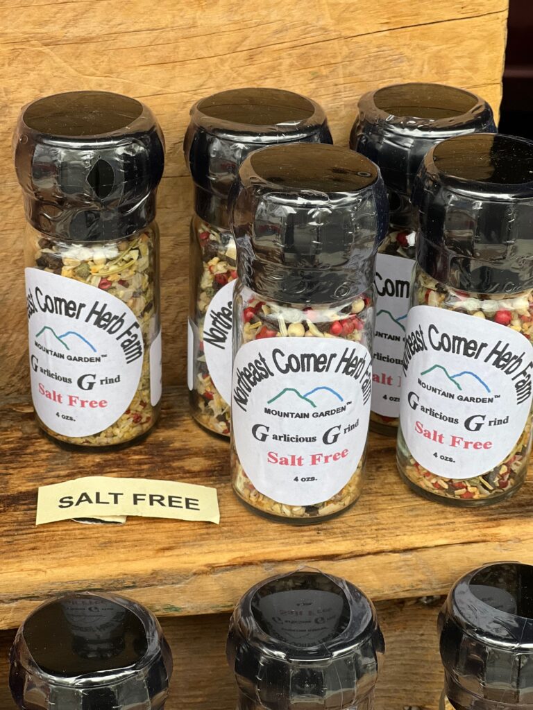 Jars of salt-free seasoning blends on a wooden shelf.