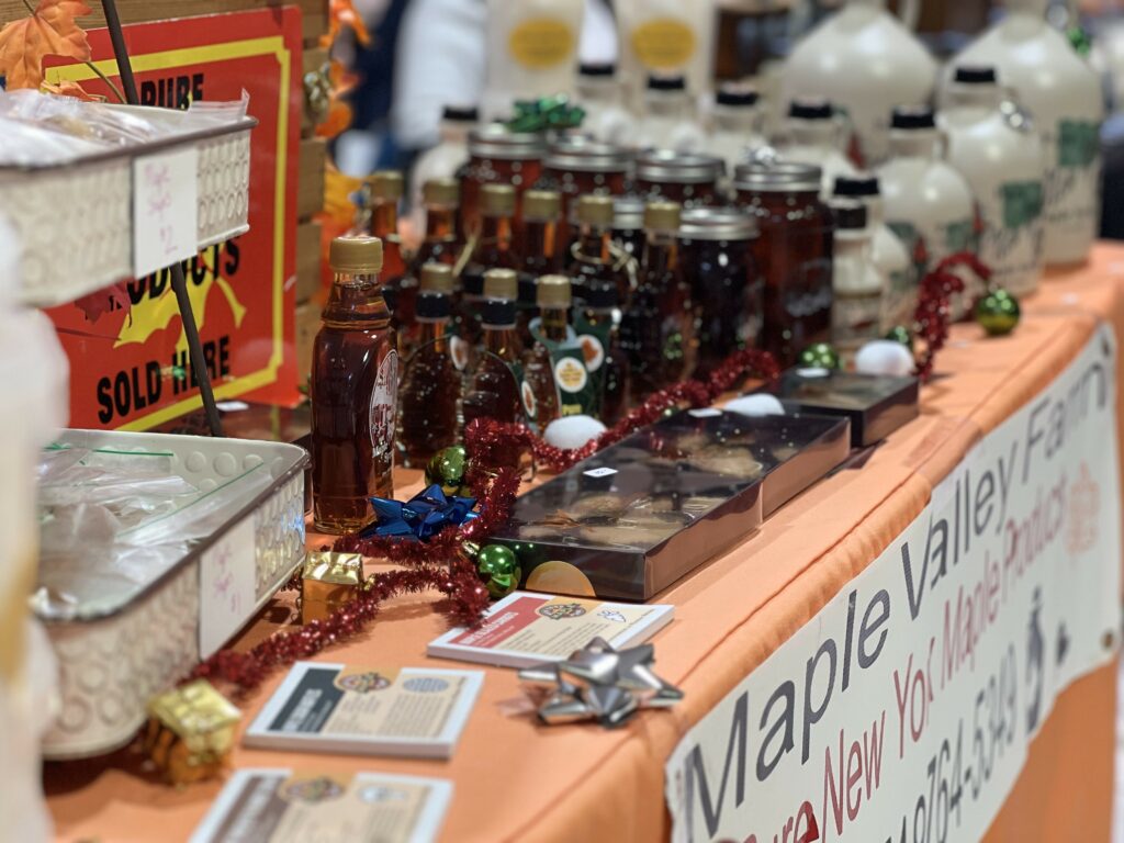 Maple syrup products on display at a farm market booth.