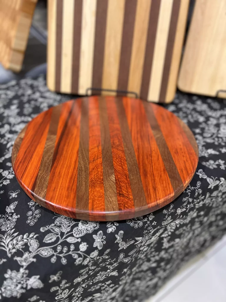 Striped wooden cutting board on patterned fabric.