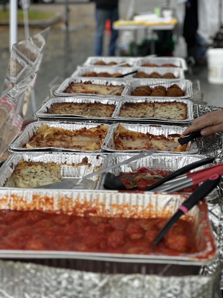 Catering food trays with lasagna and meatballs at event.