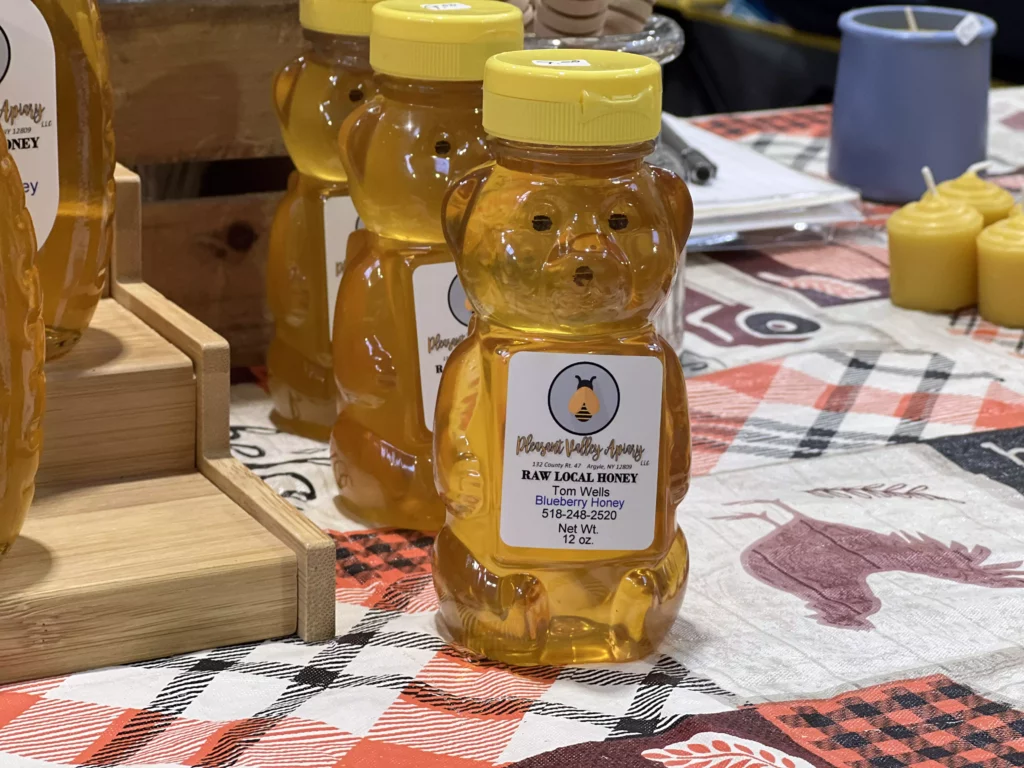 Bear-shaped honey bottles on checkered tablecloth.